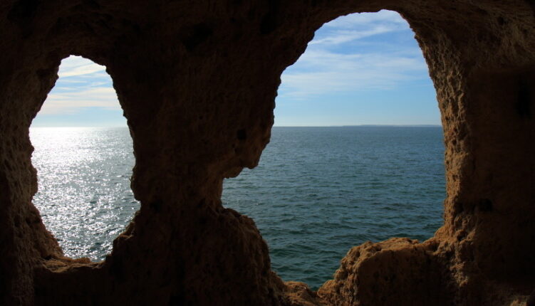 view of the sea through arches in algar seco, carvoeiro