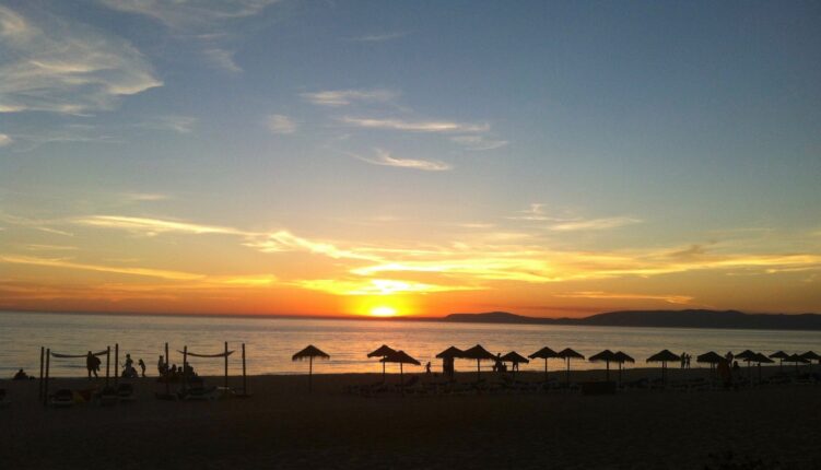 watching sunset across a beach and bay in Portugal