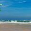 blue skies, kite surfer close to beach