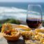 Glass of wine and Pastel de nata overlooking the waves