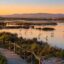 Autumn birdwatching in the Algarve: flamingos and spoonbills feeding in a calm coastal lagoon at golden-hour dawn.